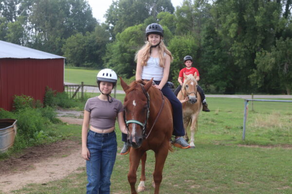 image of several campers participating in horseback riding.