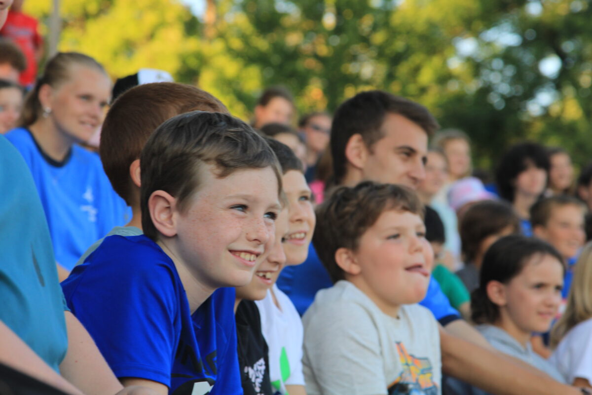 a group of boys sitting together at camp orientation.