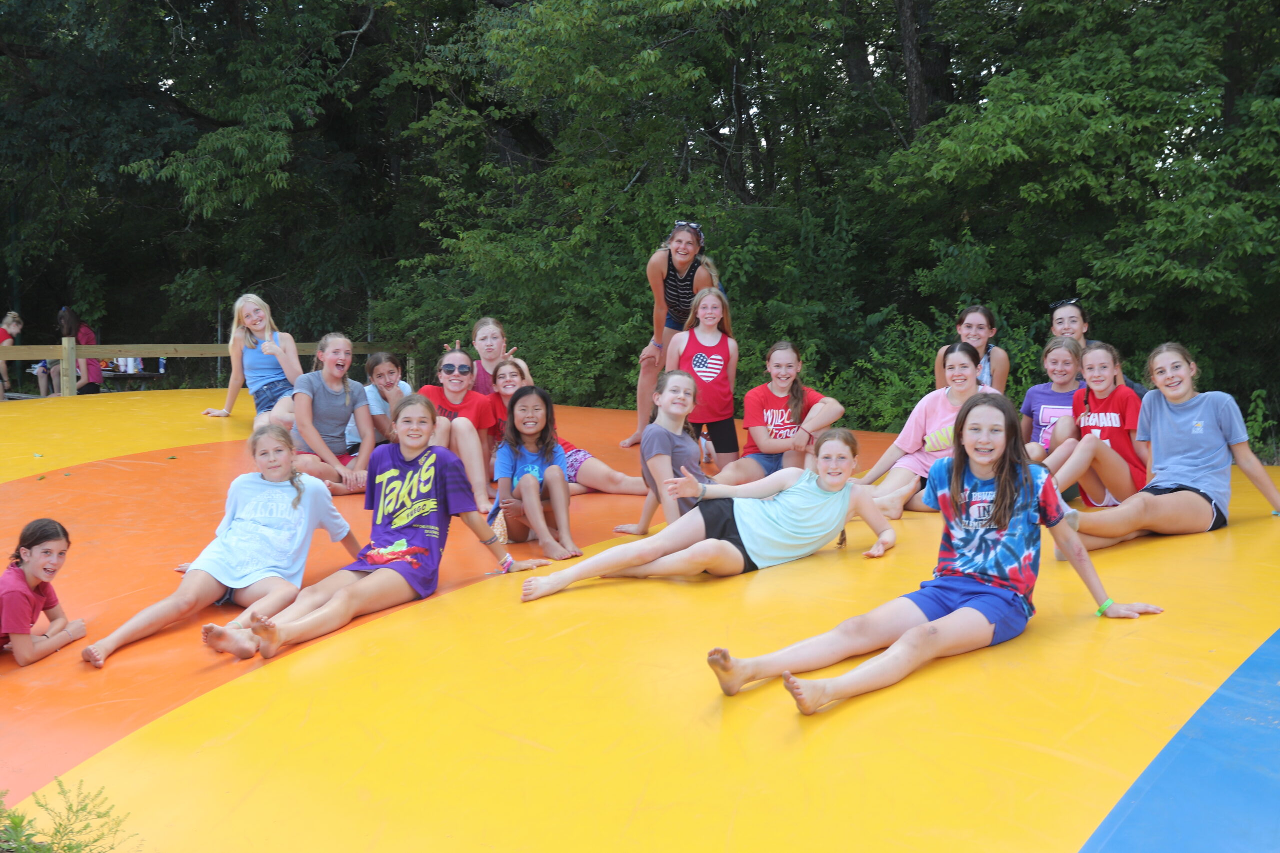 A group of girls sitting together on the jumping pillow.