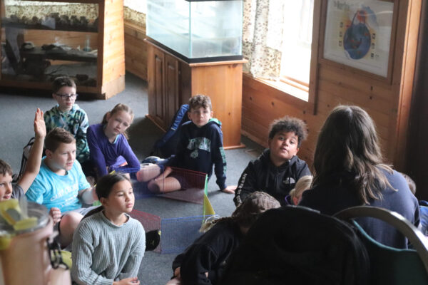 A group of children sitting in an environmental education course.