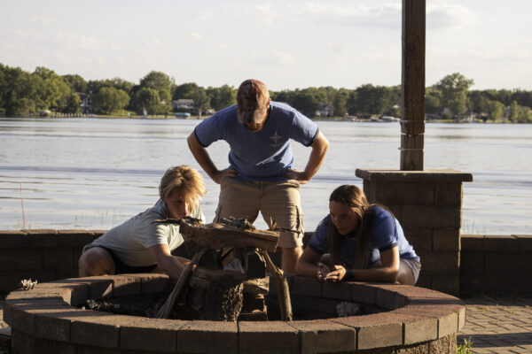 A group of camp counselors working to build a fire together.